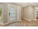 Inviting foyer features a glass-paneled front door and light herringbone flooring at 2103 Harbourside Dr # 1102, Longboat Key, FL 34228