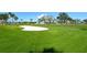 Lush green golf course view featuring a sand trap, palm trees, and manicured lawns for an idyllic outdoor experience at 2103 Harbourside Dr # 1102, Longboat Key, FL 34228
