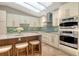 Bright kitchen with island, stone countertops, stainless steel appliances, and tile backsplash at 2103 Harbourside Dr # 1102, Longboat Key, FL 34228