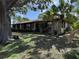 Single story home with stone facade, mature trees, and lush lawn at 211 55Th Nw St, Bradenton, FL 34209