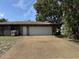 Front view of a two-car garage with adjacent entrance door and wide driveway at 211 55Th Nw St, Bradenton, FL 34209