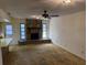 Cozy living room featuring a stone fireplace, large windows, and carpet flooring at 211 55Th Nw St, Bradenton, FL 34209
