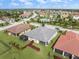 This aerial view highlights the backyard with a screened-in patio and the home's expansive green surroundings at 2316 Springhaven Ln, Lakewood Ranch, FL 34211