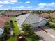 Aerial view showcases the home's gray roof, manicured landscaping, and convenient three-car garage at 2316 Springhaven Ln, Lakewood Ranch, FL 34211