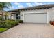 Attractive home featuring a two car garage, paver driveway and lush landscaping at 2316 Springhaven Ln, Lakewood Ranch, FL 34211