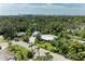 An aerial view that shows city and distant waterways behind the lush surroundings of this property at 2321 Milford Cir, Sarasota, FL 34239