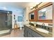 Bathroom featuring a dual sink vanity with stone countertops, a toilet, and a slate tiled walk-in shower at 2321 Milford Cir, Sarasota, FL 34239