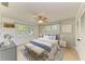 Comfortable bedroom featuring a ceiling fan, matching nightstands and bright windows at 2321 Milford Cir, Sarasota, FL 34239