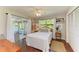 Bright bedroom with French doors leading to a sunroom, stylish decor, and hardwood floors at 2321 Milford Cir, Sarasota, FL 34239