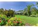 This attractive home features a metal roof, lush landscaping, and a well-maintained front lawn with flowering plants at 2321 Milford Cir, Sarasota, FL 34239