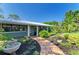 Charming single-story home with a well-manicured front yard and a stone water fountain at 2321 Milford Cir, Sarasota, FL 34239