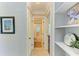 Hallway view showcasing a bathroom with a tiled shower and creative shelving at 2321 Milford Cir, Sarasota, FL 34239