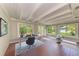Bright home office with hardwood floors, beamed ceiling, and natural light from large windows at 2321 Milford Cir, Sarasota, FL 34239