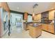 Bright kitchen features wood cabinets, a center island, and stainless steel appliances, adjoining view into the bedroom at 2321 Milford Cir, Sarasota, FL 34239