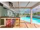 Outdoor bar area next to the pool, featuring colorful stools and a covered patio at 2321 Milford Cir, Sarasota, FL 34239
