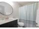 Bright bathroom with modern sink, round mirror, and a charming polka dot shower curtain at 2395 Harbor Blvd # 314, Port Charlotte, FL 33952