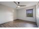 Bedroom showcasing sleek wood floors, a ceiling fan, and a sunlit window with green view at 2395 Harbor Blvd # 314, Port Charlotte, FL 33952