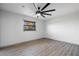 Bedroom featuring sleek wood floors, ceiling fan, and a sunlit window with leafy view at 2395 Harbor Blvd # 314, Port Charlotte, FL 33952