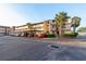 Beige condo building with carports, palm trees, and well-maintained landscaping near the entrance at 2395 Harbor Blvd # 314, Port Charlotte, FL 33952