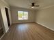 Comfortable bedroom featuring new flooring, ceiling fan, large window, and closet at 2613 Pine Lake Ter # C, Sarasota, FL 34237