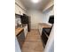 Galley kitchen with wooden countertops, stainless steel appliances, and white cabinets at 2613 Pine Lake Ter # C, Sarasota, FL 34237
