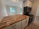 Modern kitchen with stylish cabinets, butcher block countertop, and stainless-steel appliances at 2613 Pine Lake Ter # C, Sarasota, FL 34237