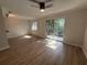 Bright living room features new flooring, ceiling fan, and sliding glass door to outdoor deck at 2613 Pine Lake Ter # C, Sarasota, FL 34237
