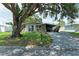 Traditional single-story house with a covered driveway near the entrance, surrounded by mature trees at 3307 Miami Pl, Bradenton, FL 34207