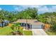 Charming single-story home with manicured lawn, mature trees, and an attached two-car garage at 3525 Riviera Dr, Sarasota, FL 34232