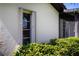 Exterior view showcasing textured wall finish, window with shutters, and manicured shrubs at 3615 Puerta Ct # 8516, Sarasota, FL 34232