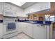 Bright kitchen featuring white cabinets with dark countertops and stainless steel appliances at 3615 Puerta Ct # 8516, Sarasota, FL 34232