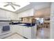 Open kitchen with white appliances, sleek countertops, and a breakfast bar at 3615 Puerta Ct # 8516, Sarasota, FL 34232