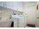 Laundry room featuring modern appliances, storage cabinets, and a utility sink at 3615 Puerta Ct # 8516, Sarasota, FL 34232