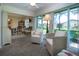 Bright sunroom featuring wicker chairs, a ceiling fan, and scenic views through large windows at 3615 Puerta Ct # 8516, Sarasota, FL 34232