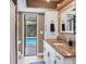 Bathroom featuring a granite vanity, white cabinets, and access to an outdoor pool area at 3636 Torrey Pines Blvd, Sarasota, FL 34238