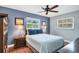 Cozy bedroom featuring hardwood floors, a ceiling fan, and large windows with natural light at 3636 Torrey Pines Blvd, Sarasota, FL 34238