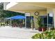 Outdoor patio at the Serendipity Racquet Club with blue awning, tables and chairs at 3636 Torrey Pines Blvd, Sarasota, FL 34238
