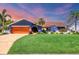 Charming single-story home featuring vibrant blue exterior, lush lawn, beautiful landscaping, and a wooden garage door at 3636 Torrey Pines Blvd, Sarasota, FL 34238