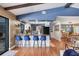 Open kitchen featuring a breakfast bar, granite countertops, and stylish blue barstools with a seamless flow into the dining area at 3636 Torrey Pines Blvd, Sarasota, FL 34238