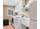 Functional laundry room with modern washer, dryer, utility sink, and ample storage cabinets at 3636 Torrey Pines Blvd, Sarasota, FL 34238