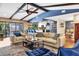 Open-concept living room featuring vaulted ceilings, wood beams, and views of kitchen and outdoor pool area at 3636 Torrey Pines Blvd, Sarasota, FL 34238