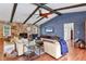 Cozy living room featuring a stone fireplace, hardwood floors, beamed ceilings, and comfortable seating at 3636 Torrey Pines Blvd, Sarasota, FL 34238