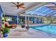 Gorgeous outdoor pool with a screened-in enclosure, blue siding, and an orange chaise lounge at 3636 Torrey Pines Blvd, Sarasota, FL 34238