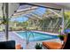 Relaxing pool with screened-in enclosure with clear open view, a handrail, and lounge chairs at 3636 Torrey Pines Blvd, Sarasota, FL 34238