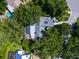 Aerial view of a screened pool and property surrounded by trees, showcasing its private outdoor space at 3900 Country View Dr, Sarasota, FL 34233