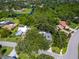 Aerial view of a property surrounded by lush greenery, water and neighborhood, offering privacy and a serene setting at 3900 Country View Dr, Sarasota, FL 34233