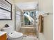 Modern bathroom with glass shower, rainfall showerhead, and stone tile at 3900 Country View Dr, Sarasota, FL 34233
