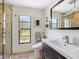 This bathroom has stone floors, a glass shower, toilet, and a vanity with a stainless steel faucet and framed mirror at 3900 Country View Dr, Sarasota, FL 34233