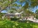 A charming house with a lush, green lawn, mature trees, and manicured landscaping creates great curb appeal at 3900 Country View Dr, Sarasota, FL 34233
