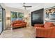 Inviting living room featuring tile floors, a ceiling fan, and a view of the backyard through a sliding glass door at 3900 Country View Dr, Sarasota, FL 34233